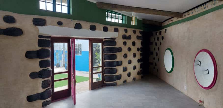 The inside of the Ulwazi Educare school building showing tyres within walls and an open door