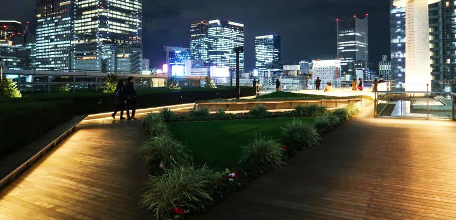 Tokyo's Marunouchi roof garden at night with the city's skyline in the background